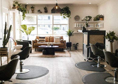 Modern, chic interior of The Acacia Salon in San Diego, California, US, featuring stylish seating and greenery.
