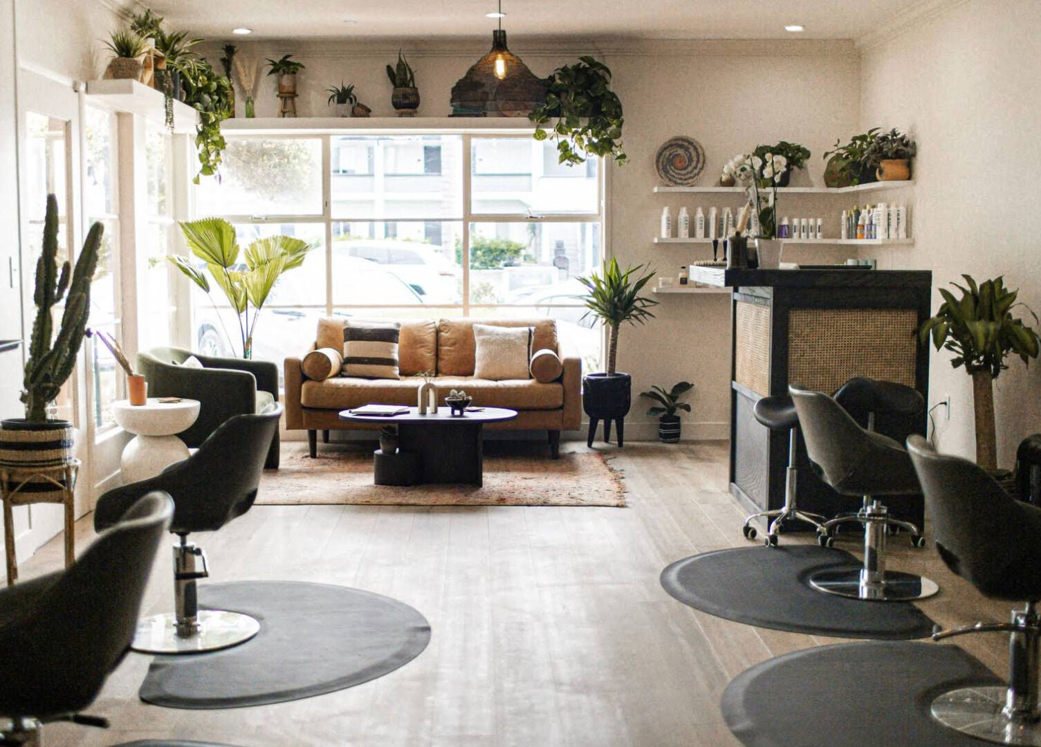Modern, chic interior of The Acacia Salon in San Diego, California, US, featuring stylish seating and greenery.