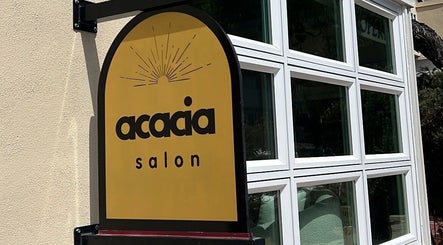 Sign of The Acacia Salon in San Diego, California, US featuring elegant black lettering on a golden background.