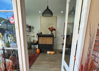 Inviting entrance of The Acacia Salon in San Diego, California, US, featuring autumn decor and natural light.