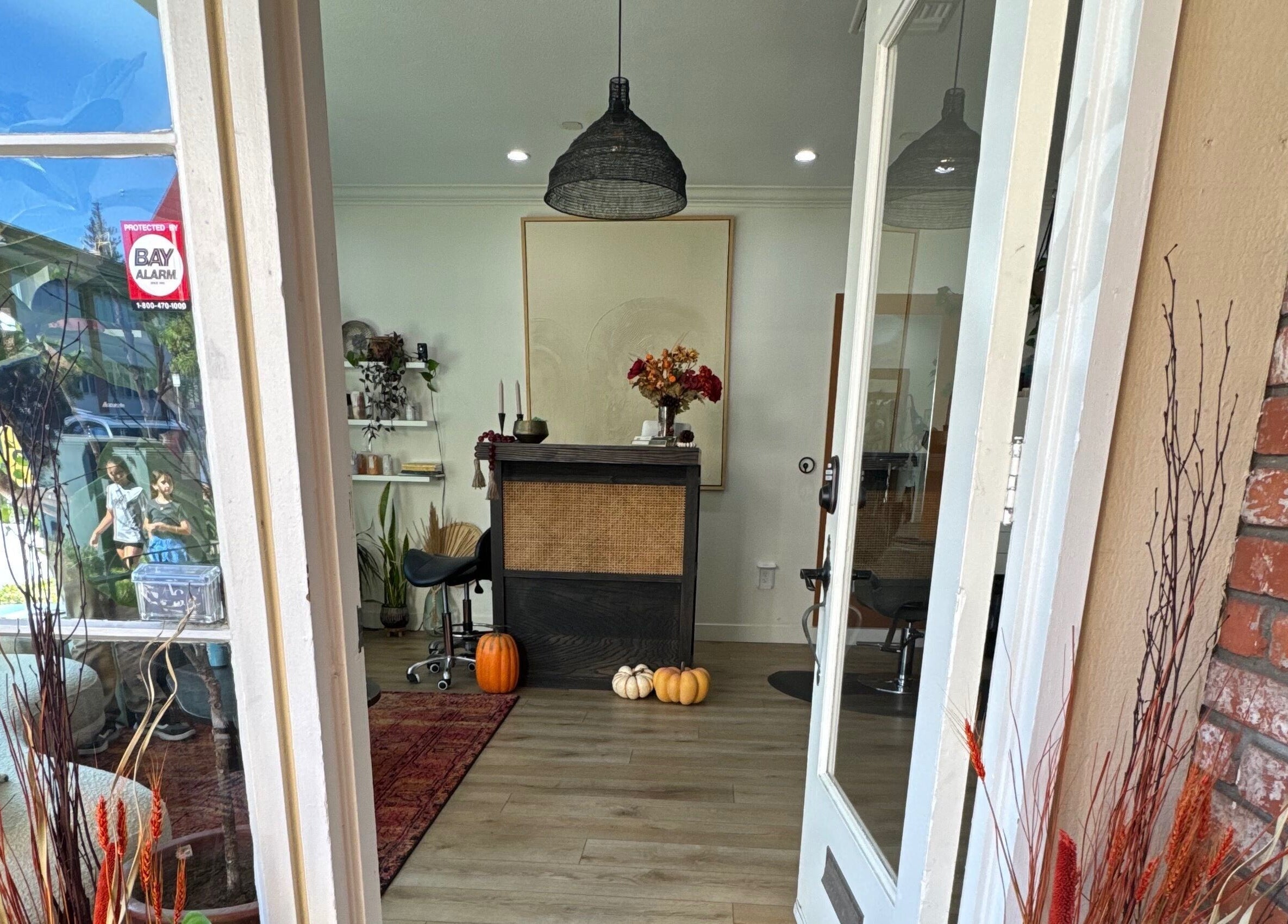 Inviting entrance of The Acacia Salon in San Diego, California, US, featuring autumn decor and natural light.