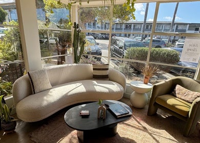 Cozy seating area at The Acacia Salon, San Diego, California, US with natural light and plants.