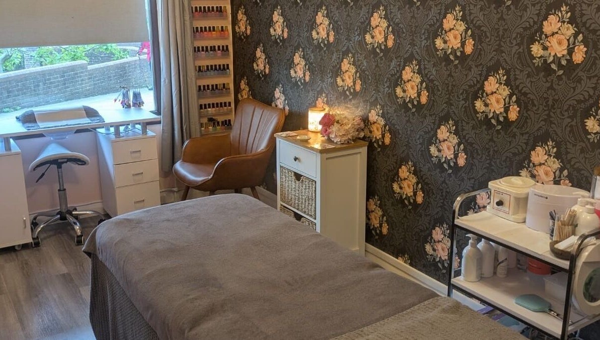 Relaxing treatment room at The Beauty Box, Battle, England, GB featuring floral wallpaper and cozy decor.
