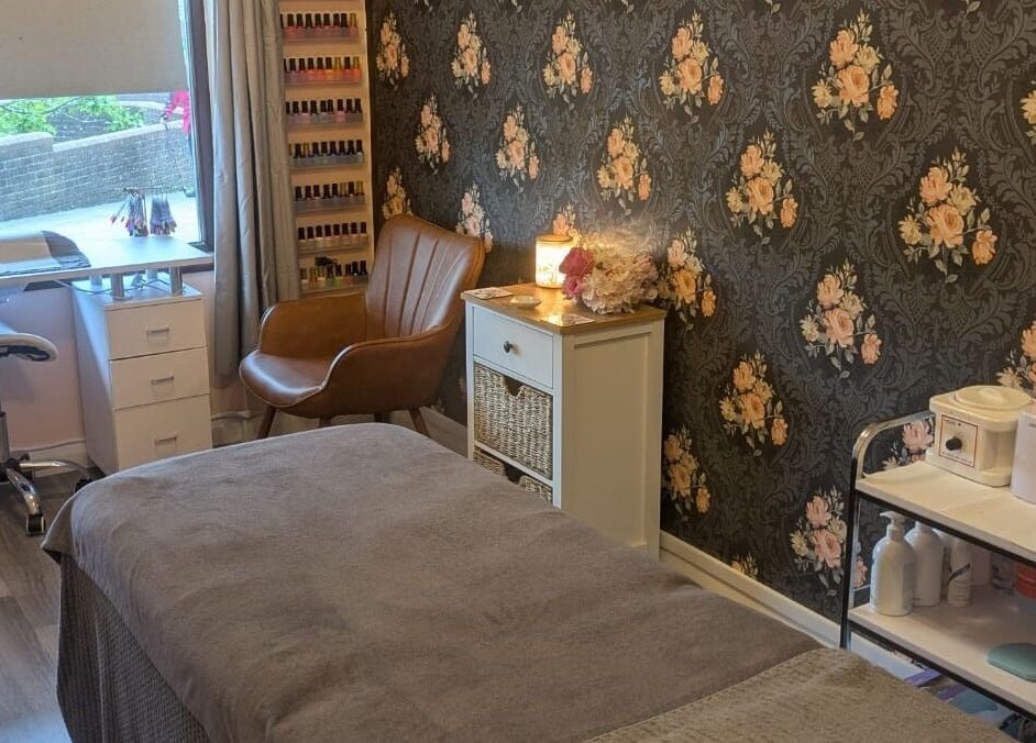 Relaxing treatment room at The Beauty Box, Battle, England, GB featuring floral wallpaper and cozy decor.