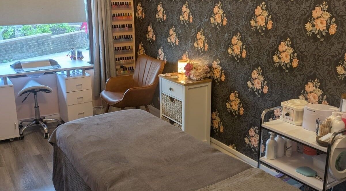 Relaxing treatment room at The Beauty Box, Battle, England, GB featuring floral wallpaper and cozy decor.