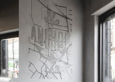 Interior wall with Anchor Lab logo at Anchor Lab, London, England, GB showcasing a map-inspired design.