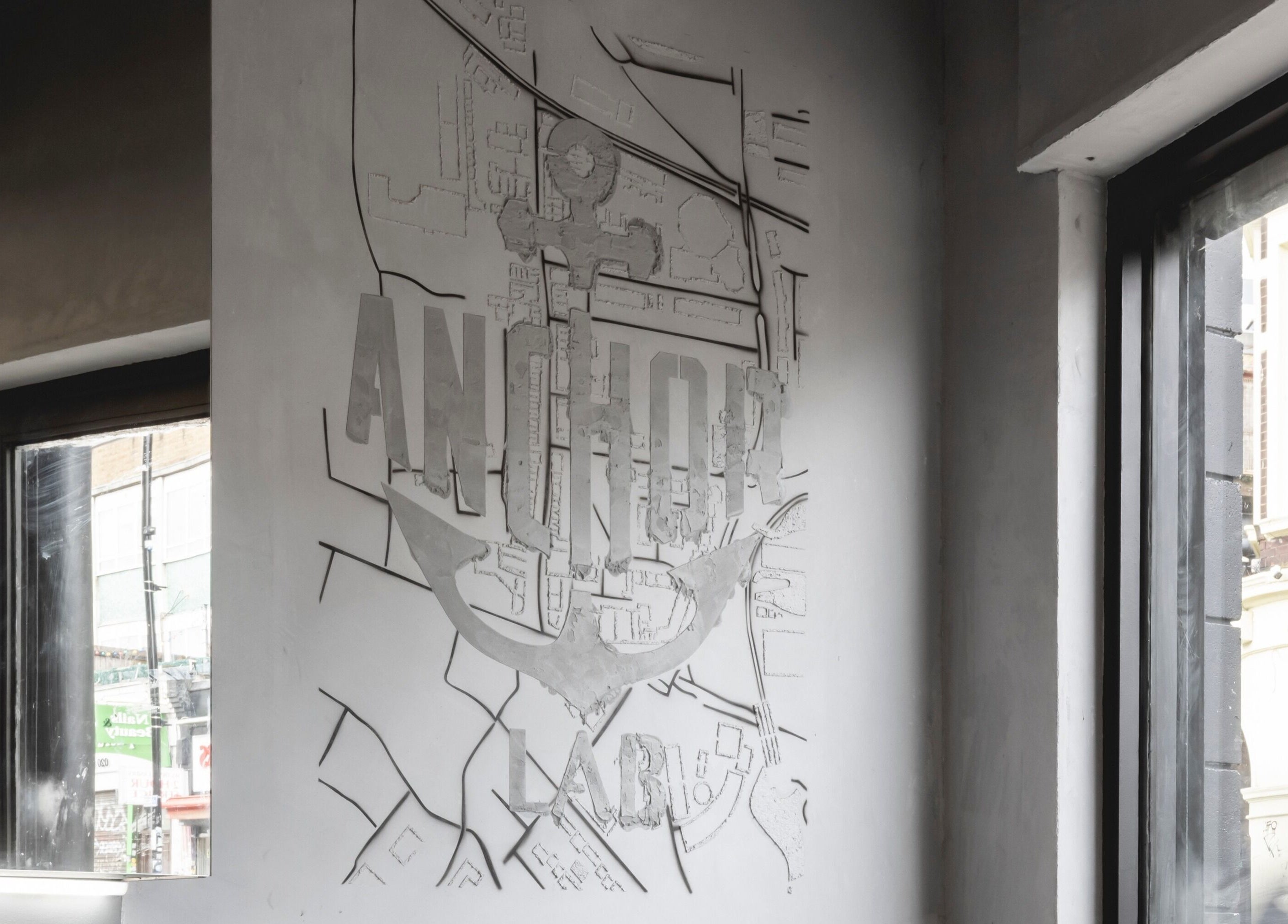 Interior wall with Anchor Lab logo at Anchor Lab, London, England, GB showcasing a map-inspired design.