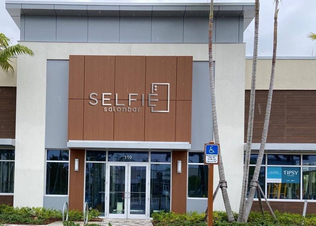 Entrance of Selfie Salonbar at Palm Beach Gardens, Florida, showcasing modern design and inviting facade.