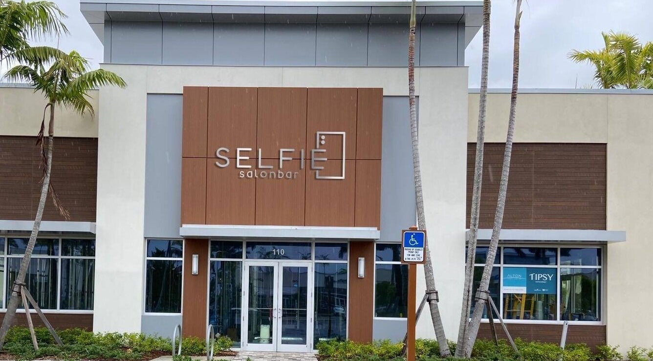 Entrance of Selfie Salonbar at Palm Beach Gardens, Florida, showcasing modern design and inviting facade.