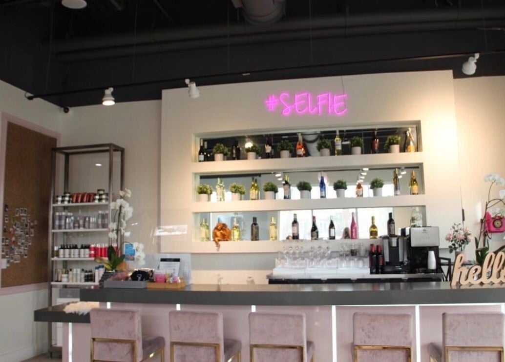 Modern bar setup at Selfie Salonbar, Palm Beach Gardens, Florida, US showcasing stylish decor and seating.