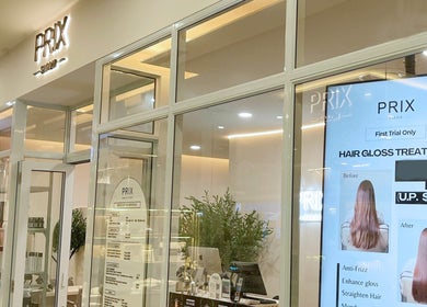 Entrance of Prix Salon in Singapore, showcasing hair gloss treatment poster and modern decor.