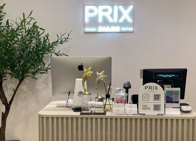 Reception desk at Prix Salon, Singapore with awards and decor, enhancing a chic ambience.