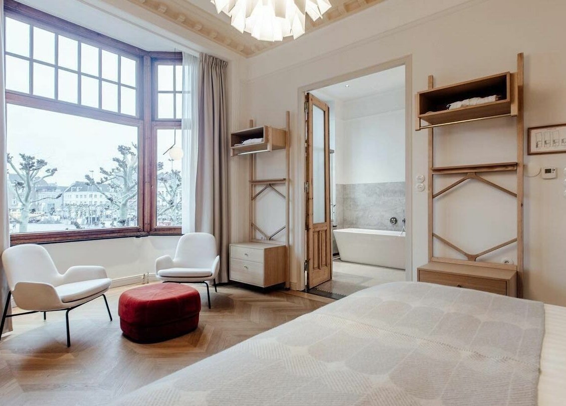 Luxurious room at Sanctum Spa, Maastricht, Limburg, NL with cozy seating and bathtub view.