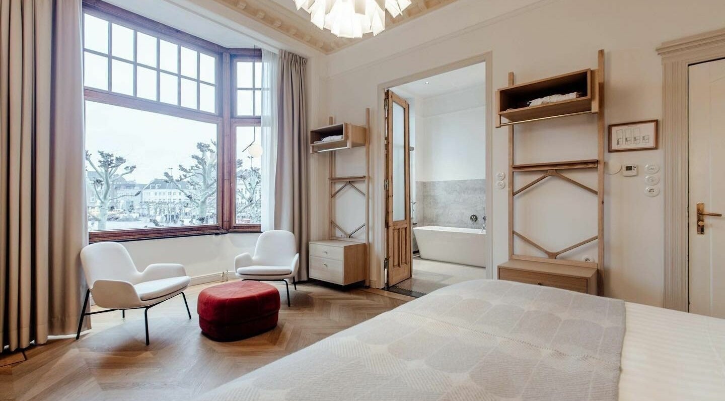 Luxurious room at Sanctum Spa, Maastricht, Limburg, NL with cozy seating and bathtub view.