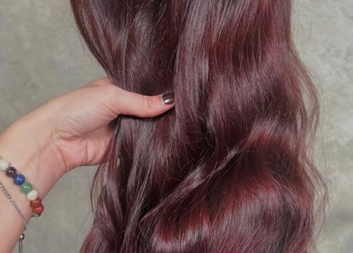 Hand showcasing glossy auburn hair at Roux - Jessica in Irlam, England, GB for vibrant color and shine.