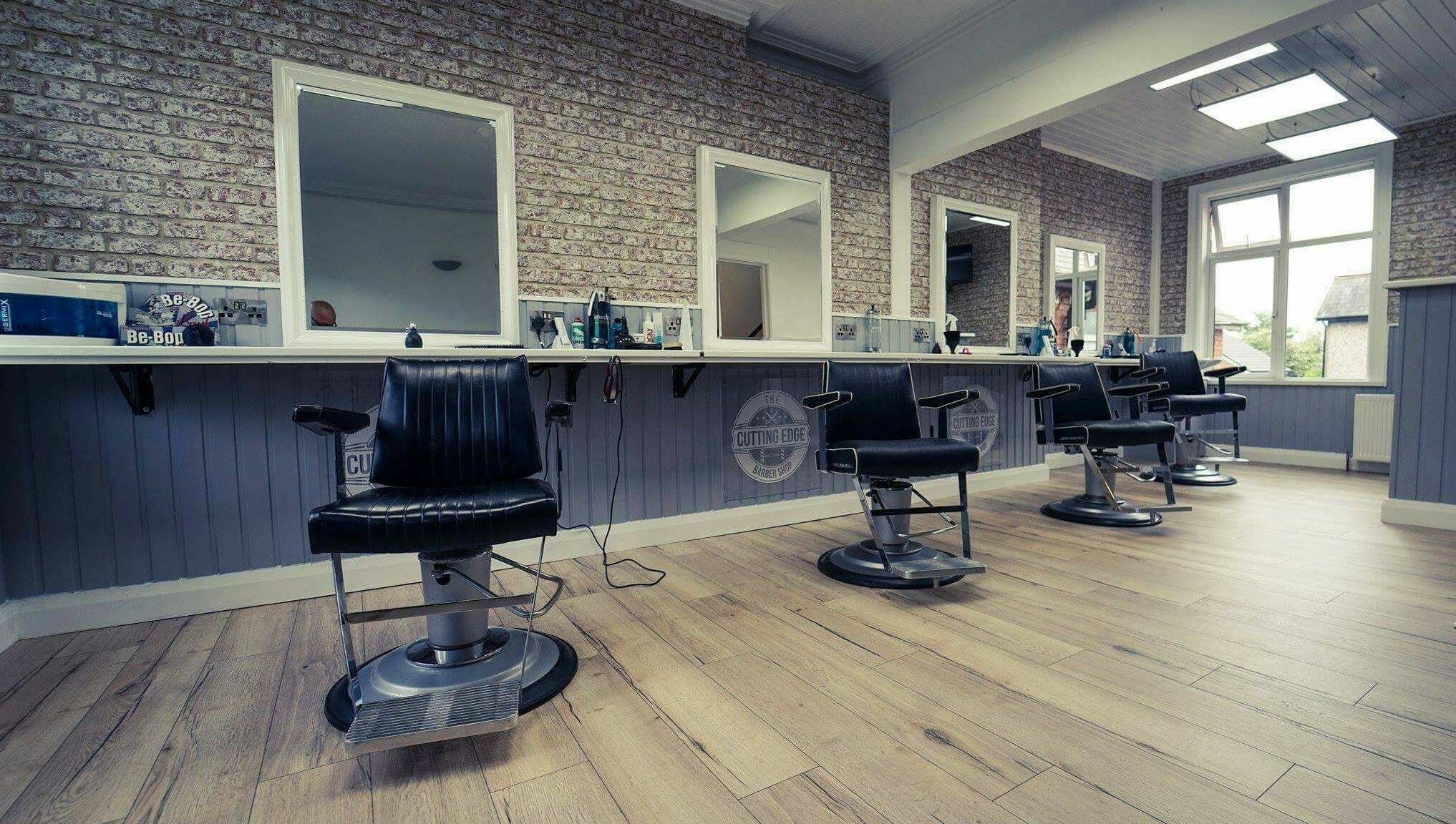 Stylish interior of The Cutting Edge Barber Shop with modern chairs in Belfast, Northern Ireland, GB.