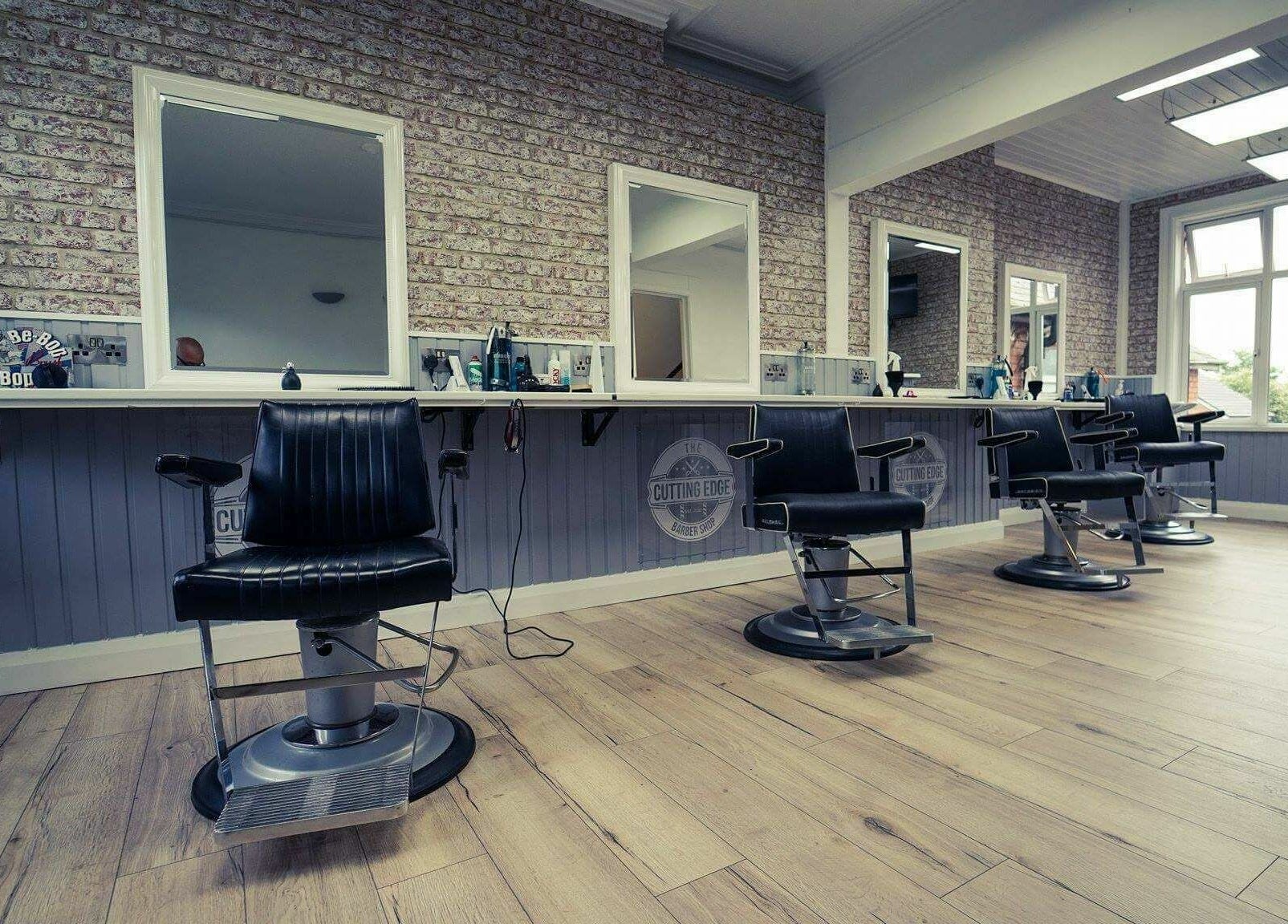 Stylish interior of The Cutting Edge Barber Shop with modern chairs in Belfast, Northern Ireland, GB.