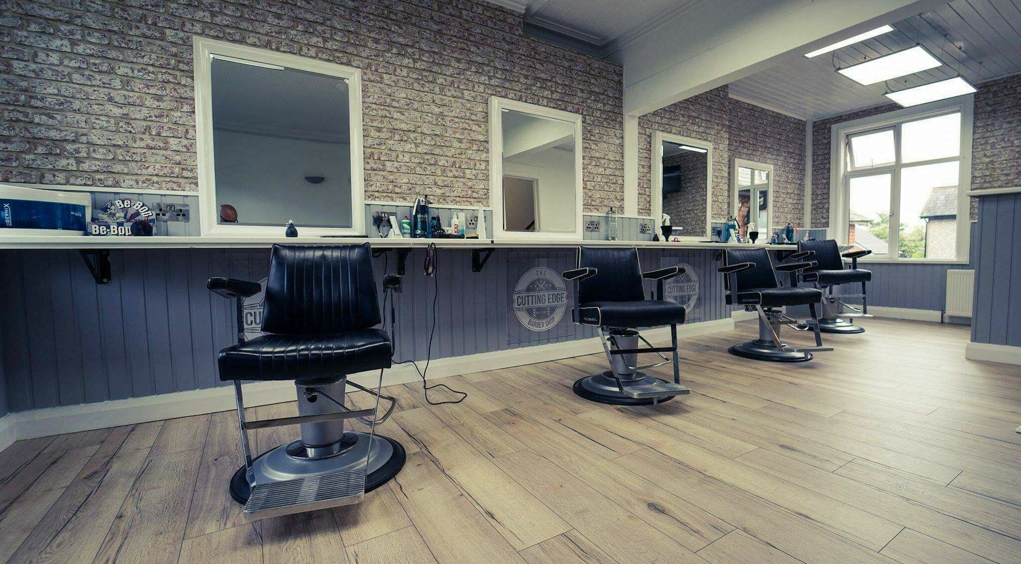 Stylish interior of The Cutting Edge Barber Shop with modern chairs in Belfast, Northern Ireland, GB.