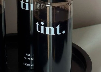 Tint spray bottles at The Spray Tan Club in Barry, Wales, GB, ready for a flawless tan experience.