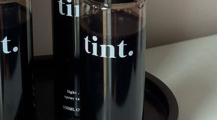 Tint spray bottles at The Spray Tan Club in Barry, Wales, GB, ready for a flawless tan experience.