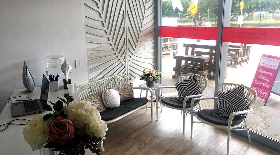 Inviting lounge area at The Waxxx Pot, Maroochydore, Queensland, AU, featuring elegant seating and floral decor.