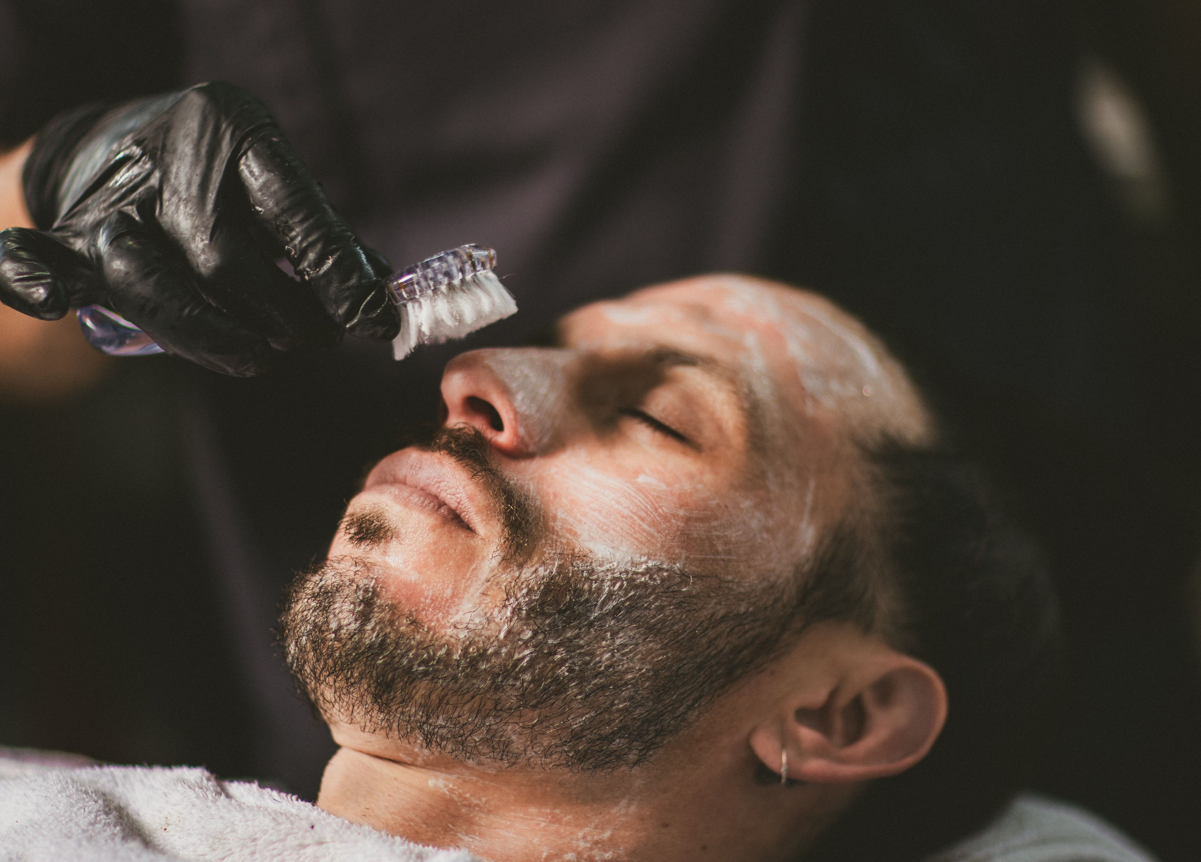 Man enjoying facial treatment at Barbería H, Tijuana, Baja California, MX.