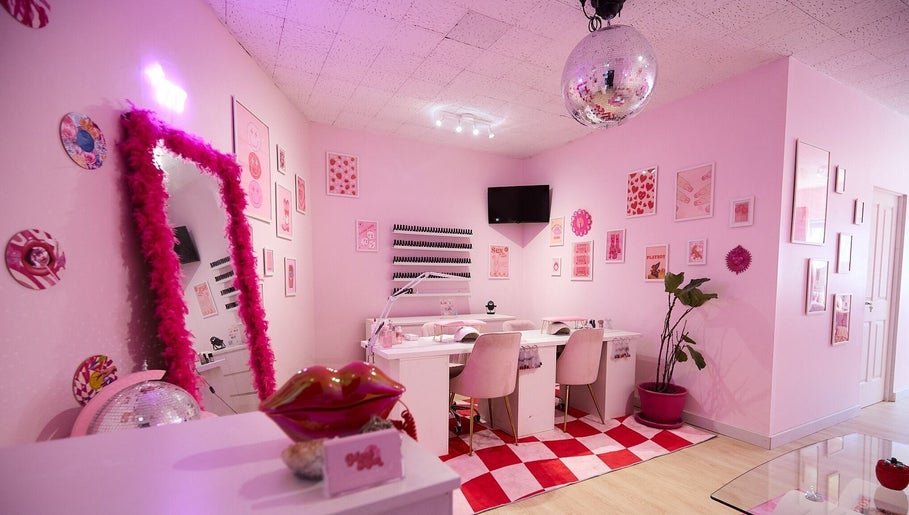Stylish pink interior of Groove Salon in Newtown, New South Wales, AU with decorative wall art and cozy seating.
