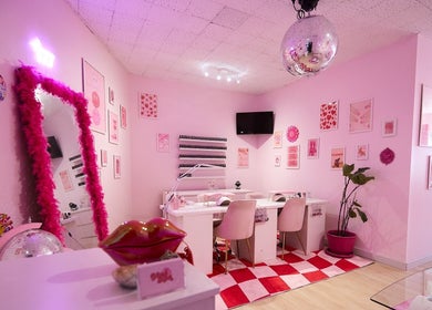 Stylish pink interior of Groove Salon in Newtown, New South Wales, AU with decorative wall art and cozy seating.