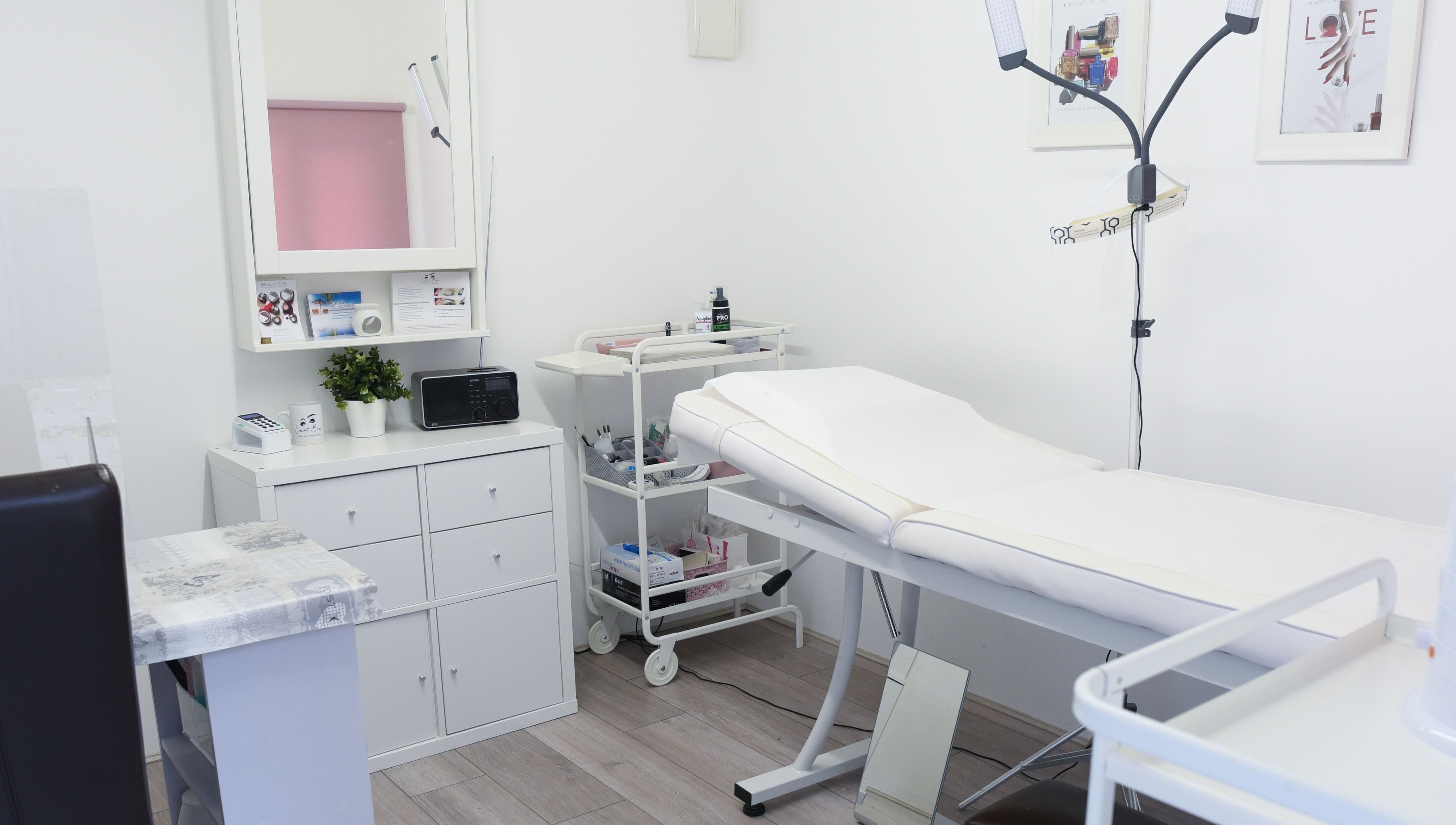 Modern treatment room at Crescent Brows in Lambourn, England, GB, showcasing white decor and sleek furnishings.