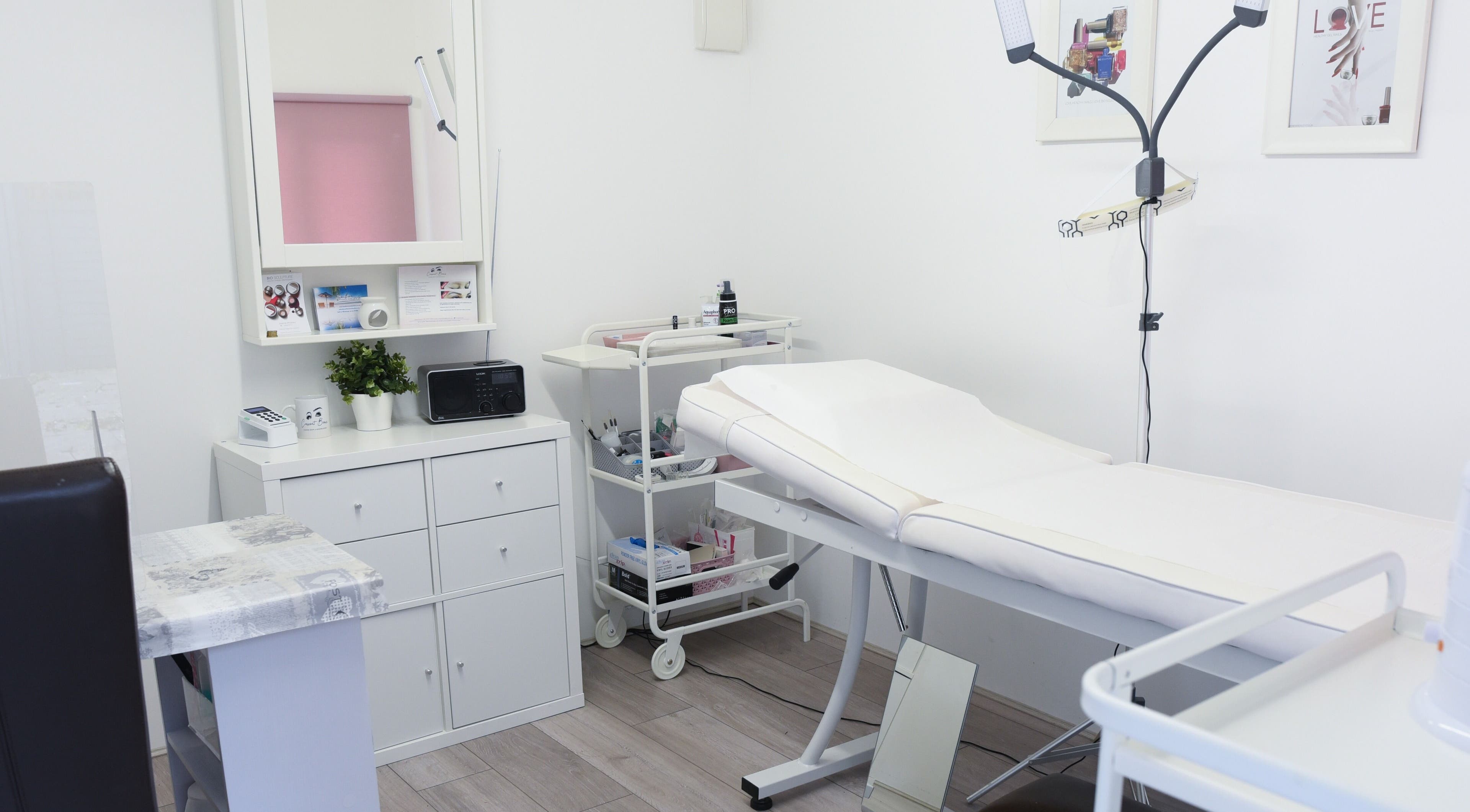 Modern treatment room at Crescent Brows in Lambourn, England, GB, showcasing white decor and sleek furnishings.