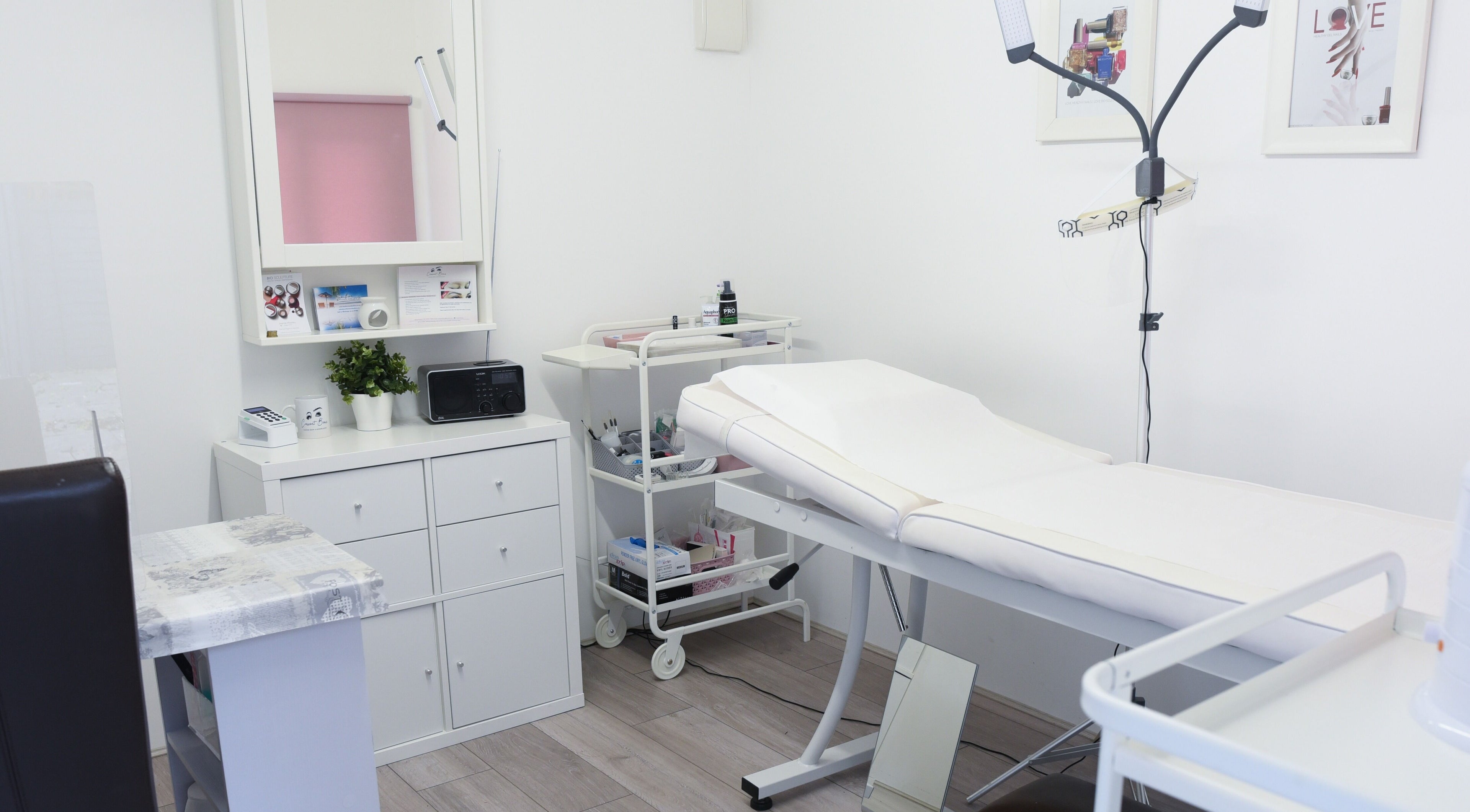 Modern treatment room at Crescent Brows in Lambourn, England, GB, showcasing white decor and sleek furnishings.