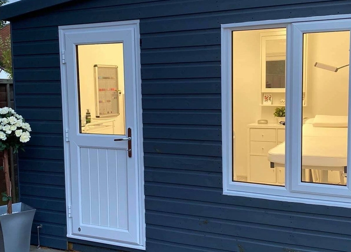 Inviting exterior of Crescent Brows salon, Lambourn, England, GB with elegant white door and window lighting.