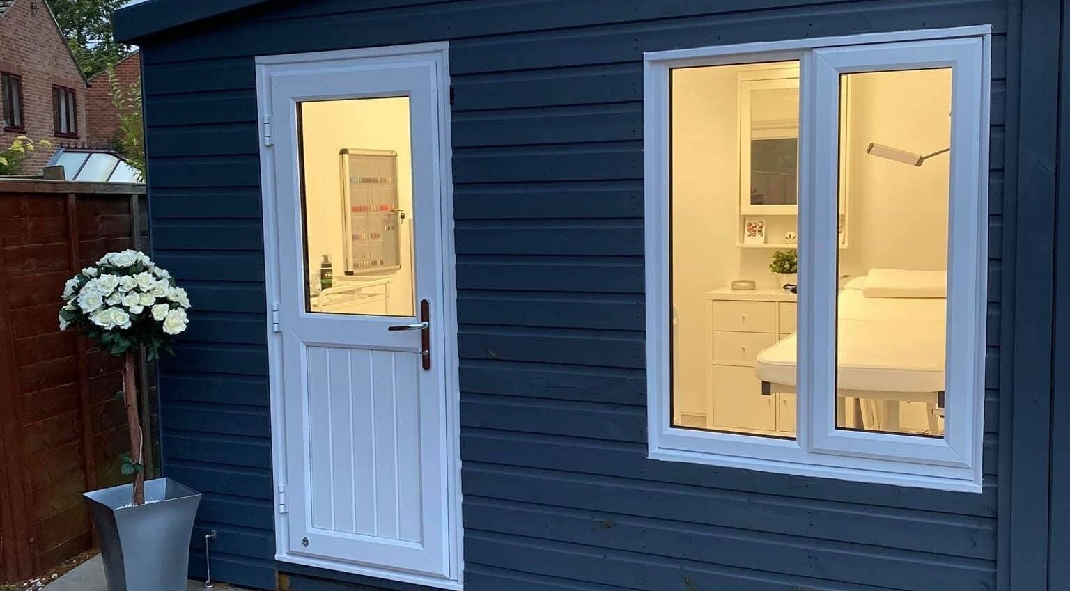 Inviting exterior of Crescent Brows salon, Lambourn, England, GB with elegant white door and window lighting.