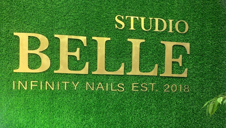 Infinity Nails signage on green wall in Windhoek, Khomas Region, NA. Stylish gold lettering enhances venue's charm.