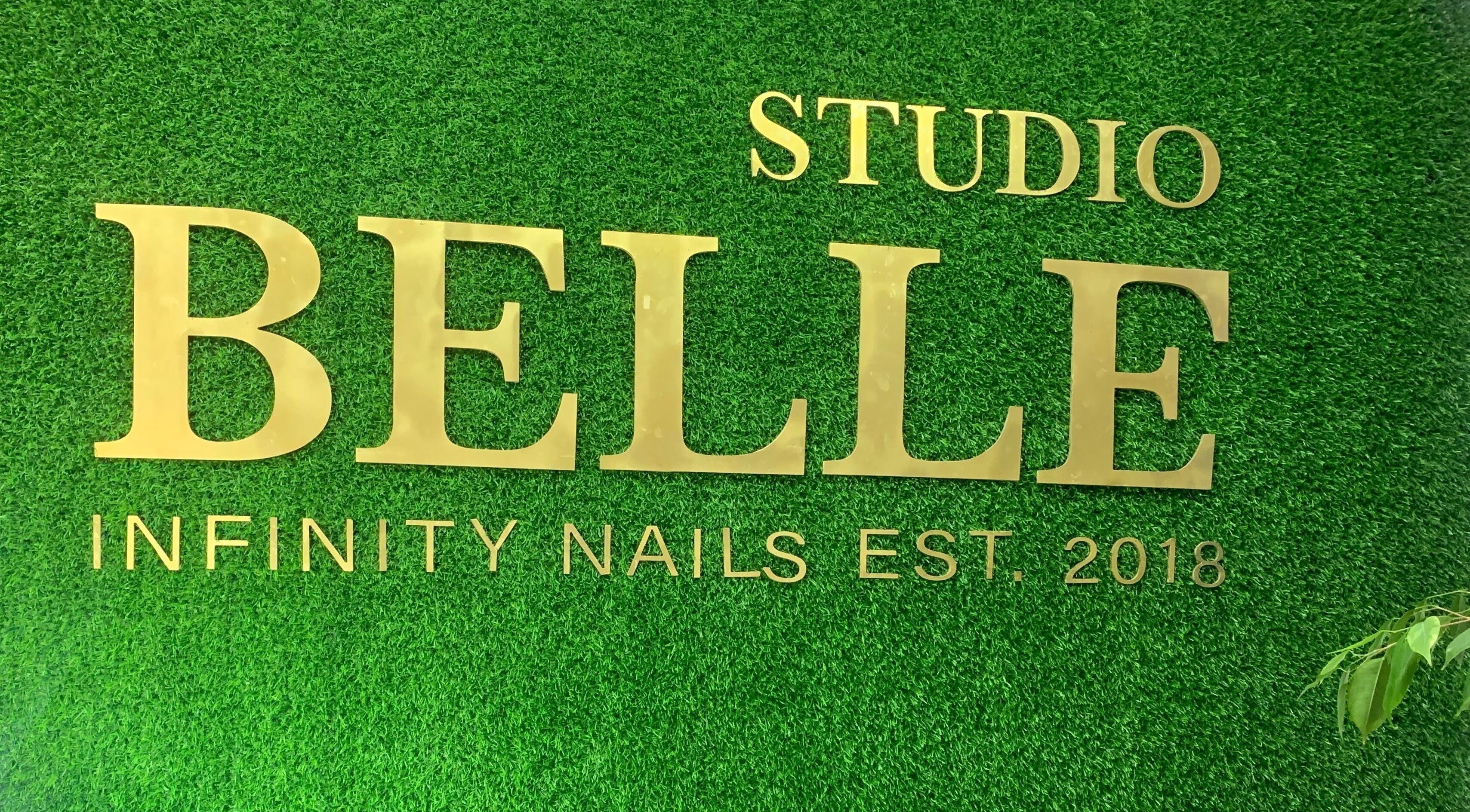 Infinity Nails signage on green wall in Windhoek, Khomas Region, NA. Stylish gold lettering enhances venue's charm.