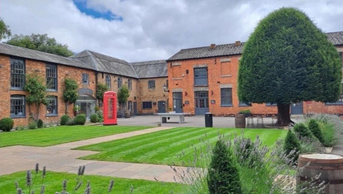 Charming brick courtyard at M Aesthetics - Wilton, featuring lush gardens in Wilton, England, GB.