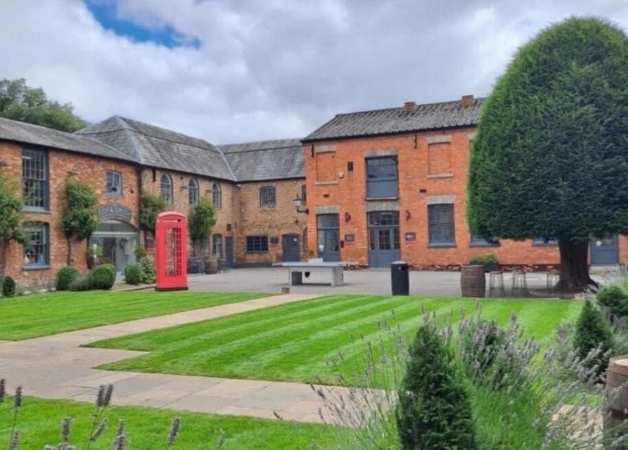 Charming brick courtyard at M Aesthetics - Wilton, featuring lush gardens in Wilton, England, GB.