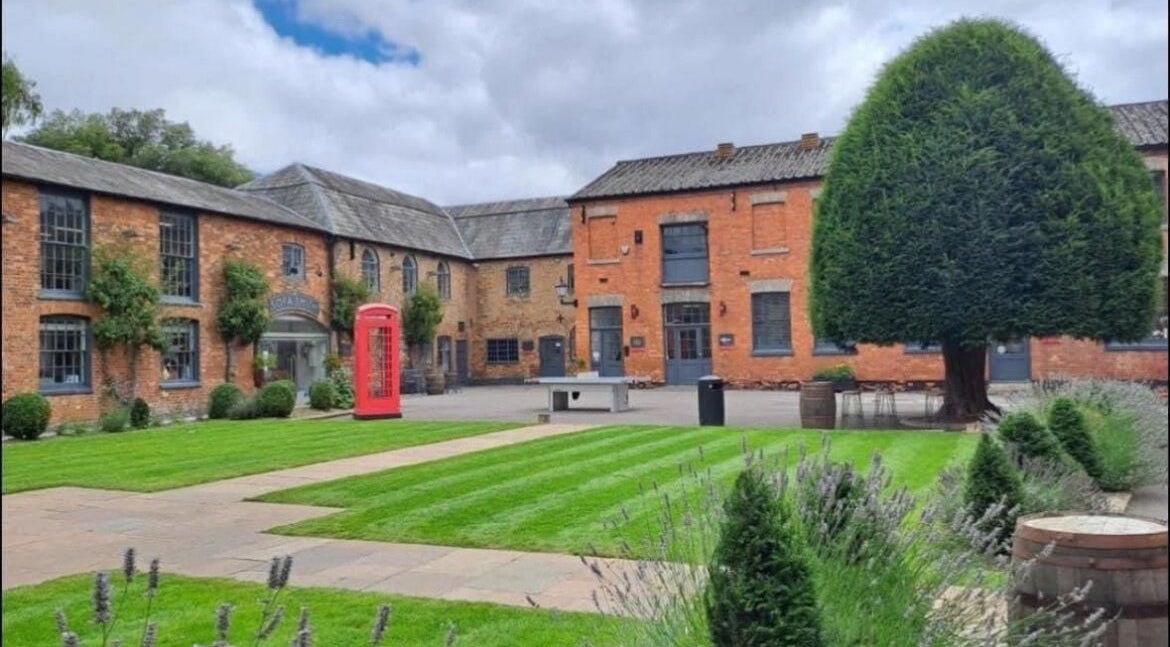 Charming brick courtyard at M Aesthetics - Wilton, featuring lush gardens in Wilton, England, GB.