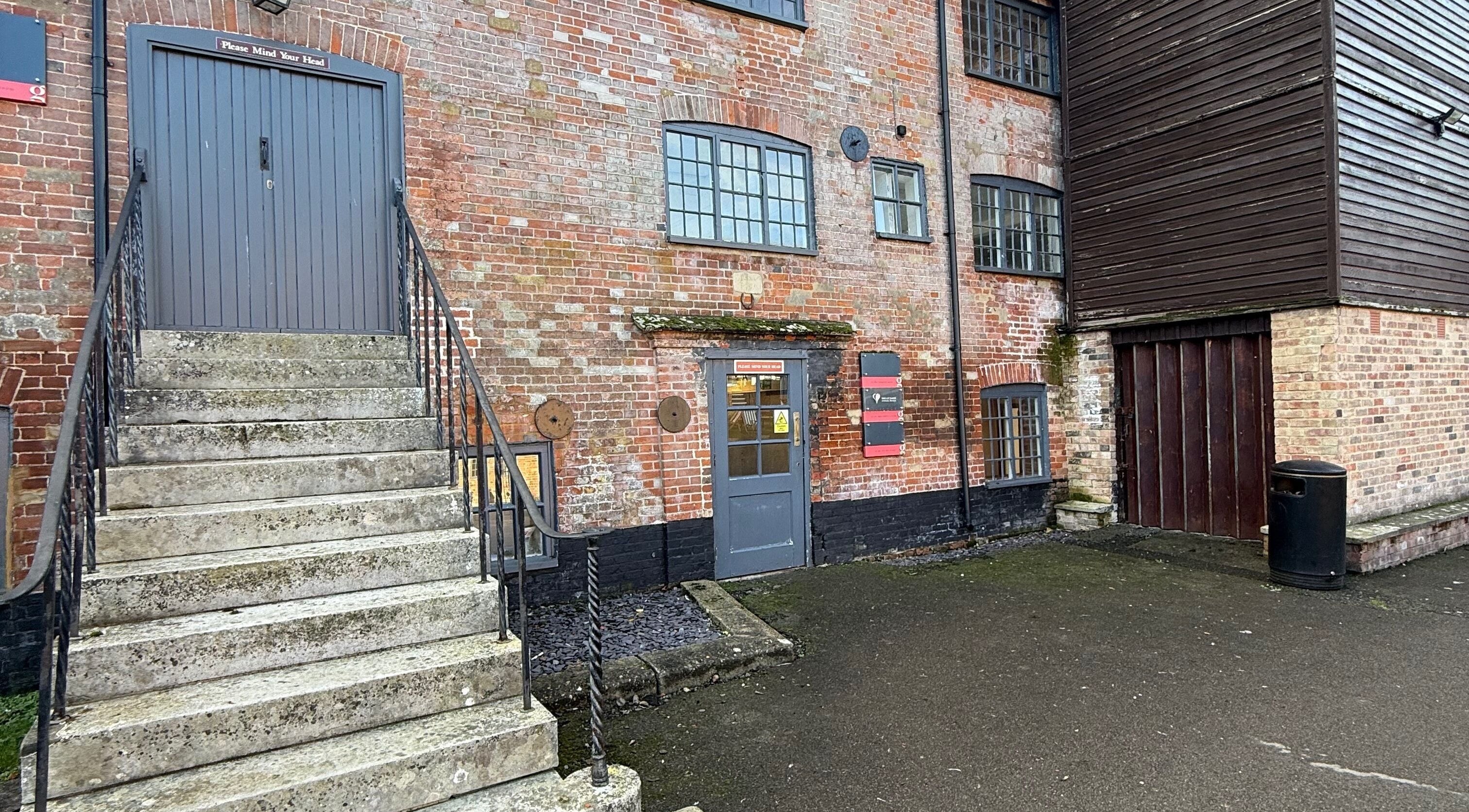 Rustic building entrance of M Aesthetics - Wilton in Wilton, England, GB, showcasing stairs and brick facade.