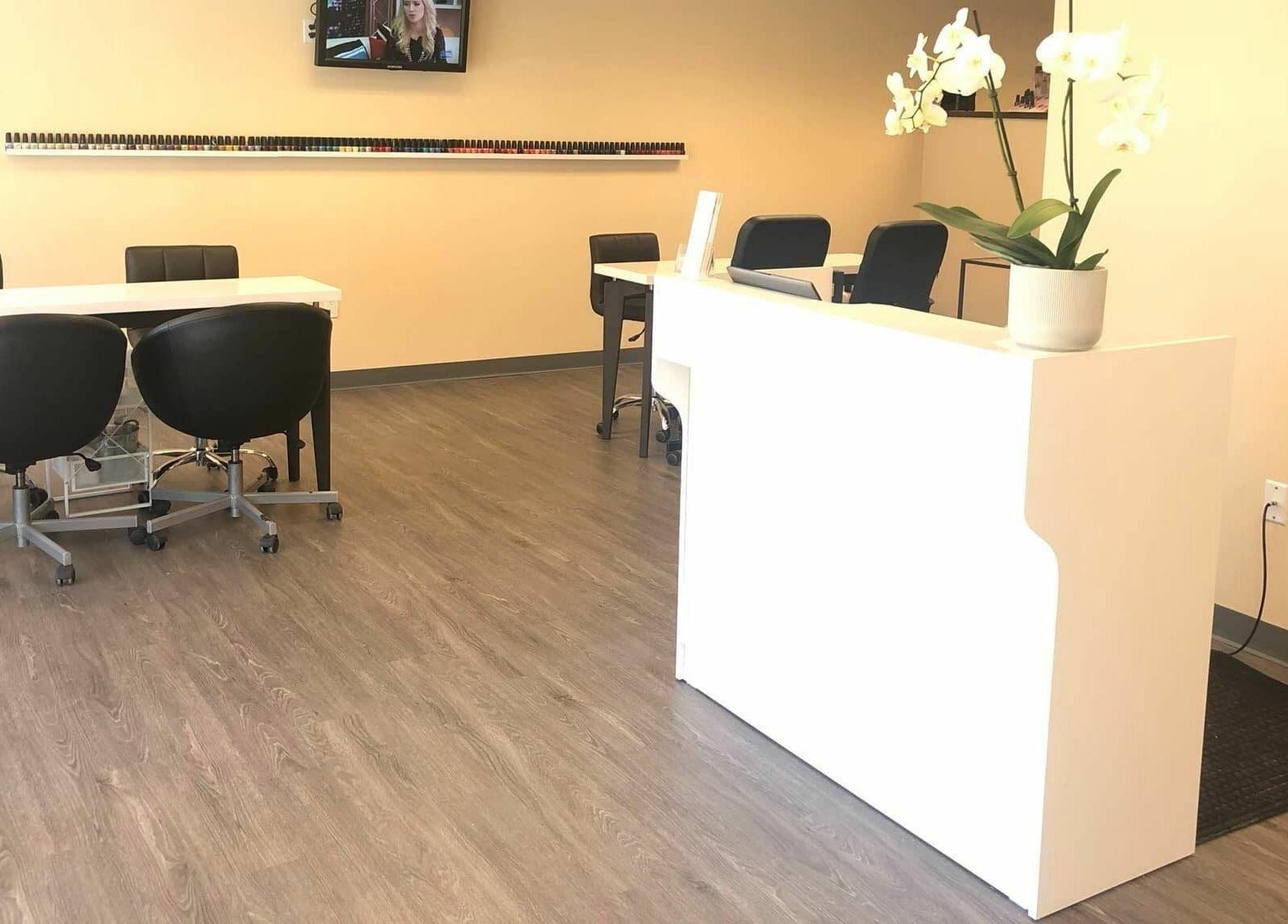 Modern interior of Orange Nail Studio in Beverly, Massachusetts, US, featuring sleek nail stations and decor.