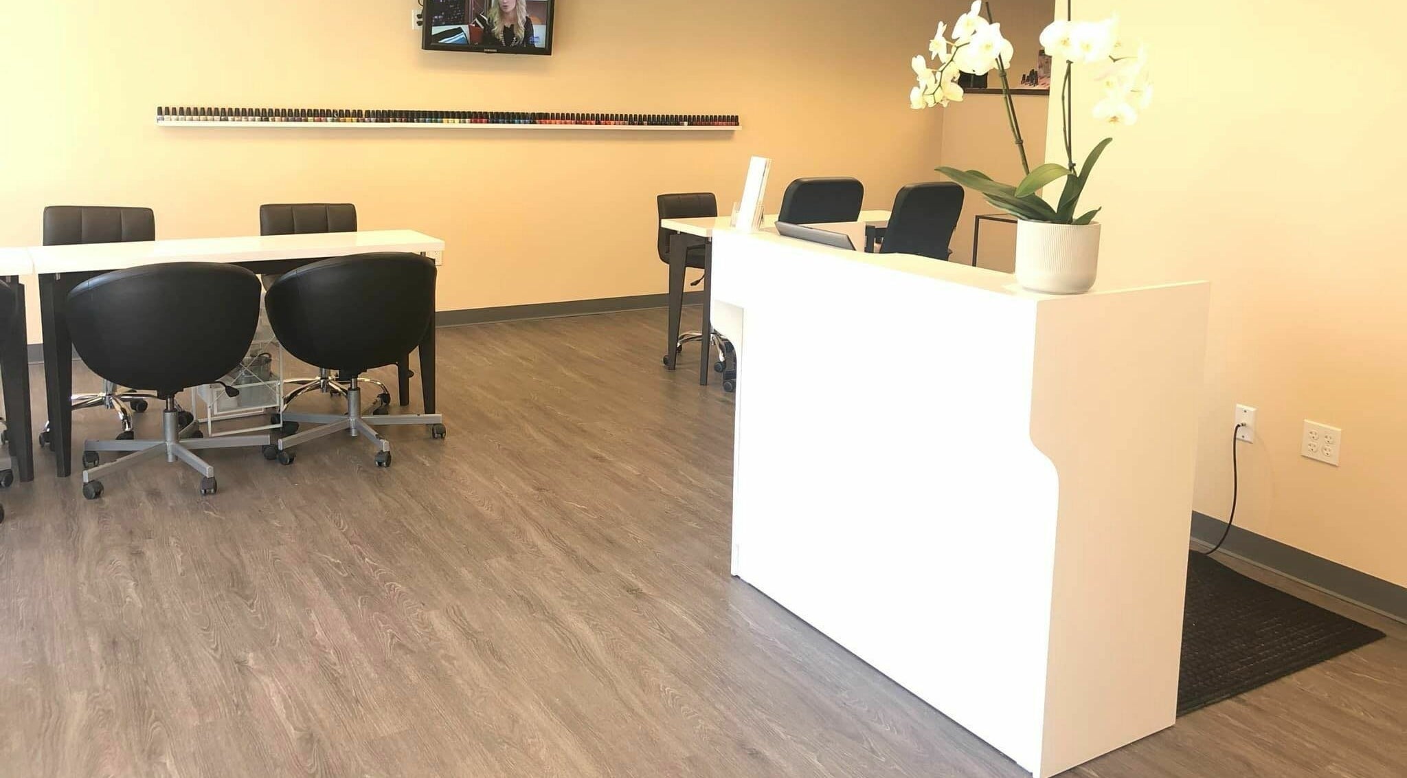 Modern interior of Orange Nail Studio in Beverly, Massachusetts, US, featuring sleek nail stations and decor.