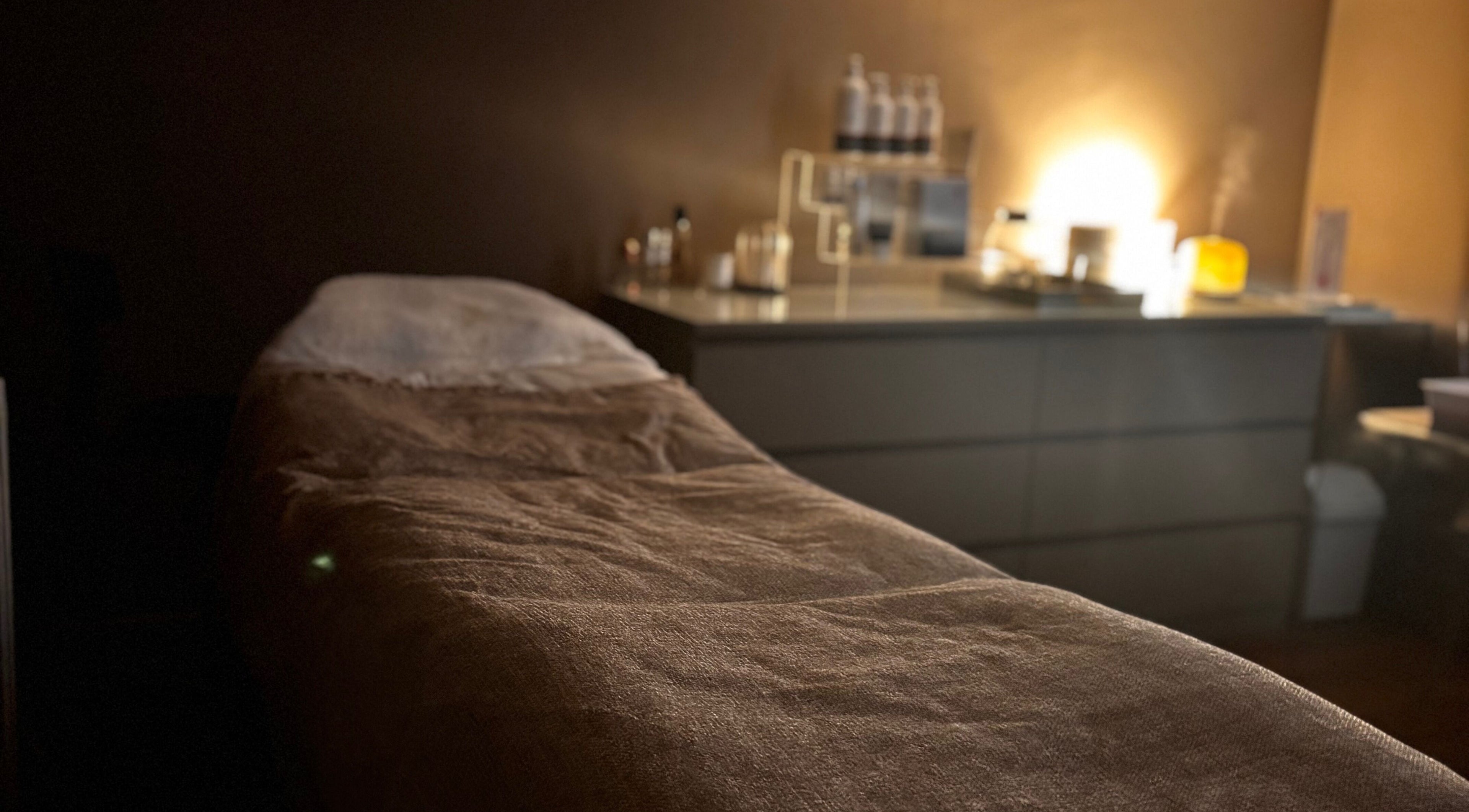 Cozy spa treatment room at Urban Spa, Morpeth, England, GB with ambient lighting and a massage table.