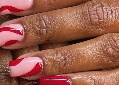 Elegant red swirl nail art at Beauticave in Krugersdorp, Gauteng, ZA. Perfect for stylish manicures.