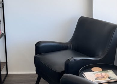 Relax in style at BW Hair, East Corrimal, with our sleek black armchair in a serene setting.