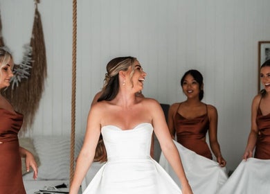 Bridesmaids assist the bride in a brown dress at BW Hair, East Corrimal, New South Wales, AU.