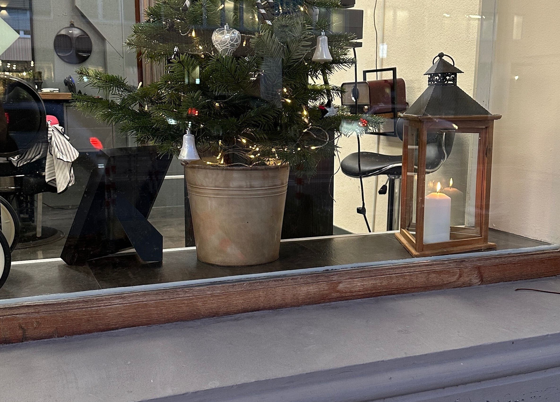 Weihnachtlich dekorierter Blick in Gorgis Barber Bern, Bern, CH mit stilvollem Stuhl und Kerze.