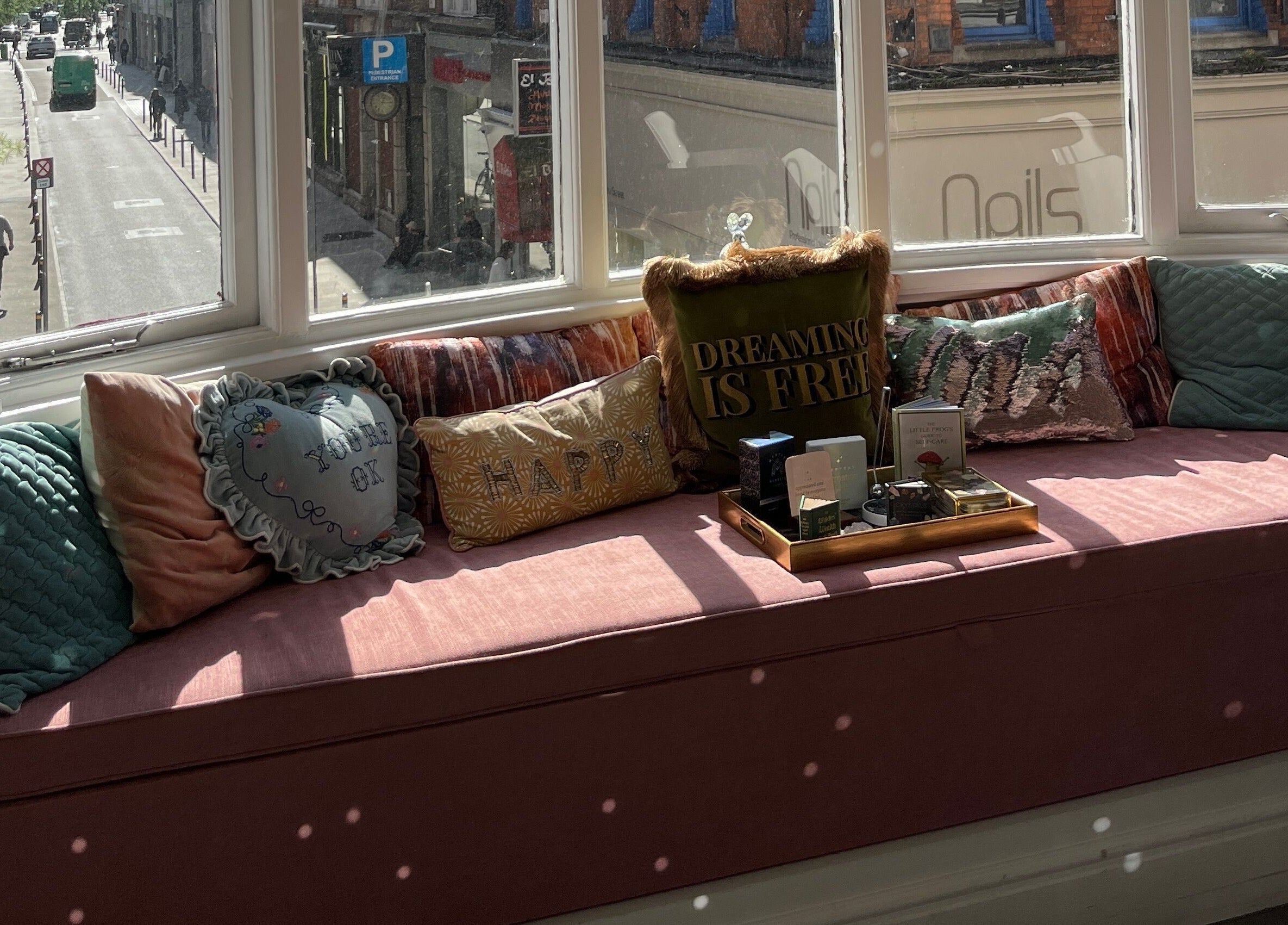 Comfortable window seating at Alchemy Lab, Dublin, Dublin, IE with decorative cushions in sunlight.