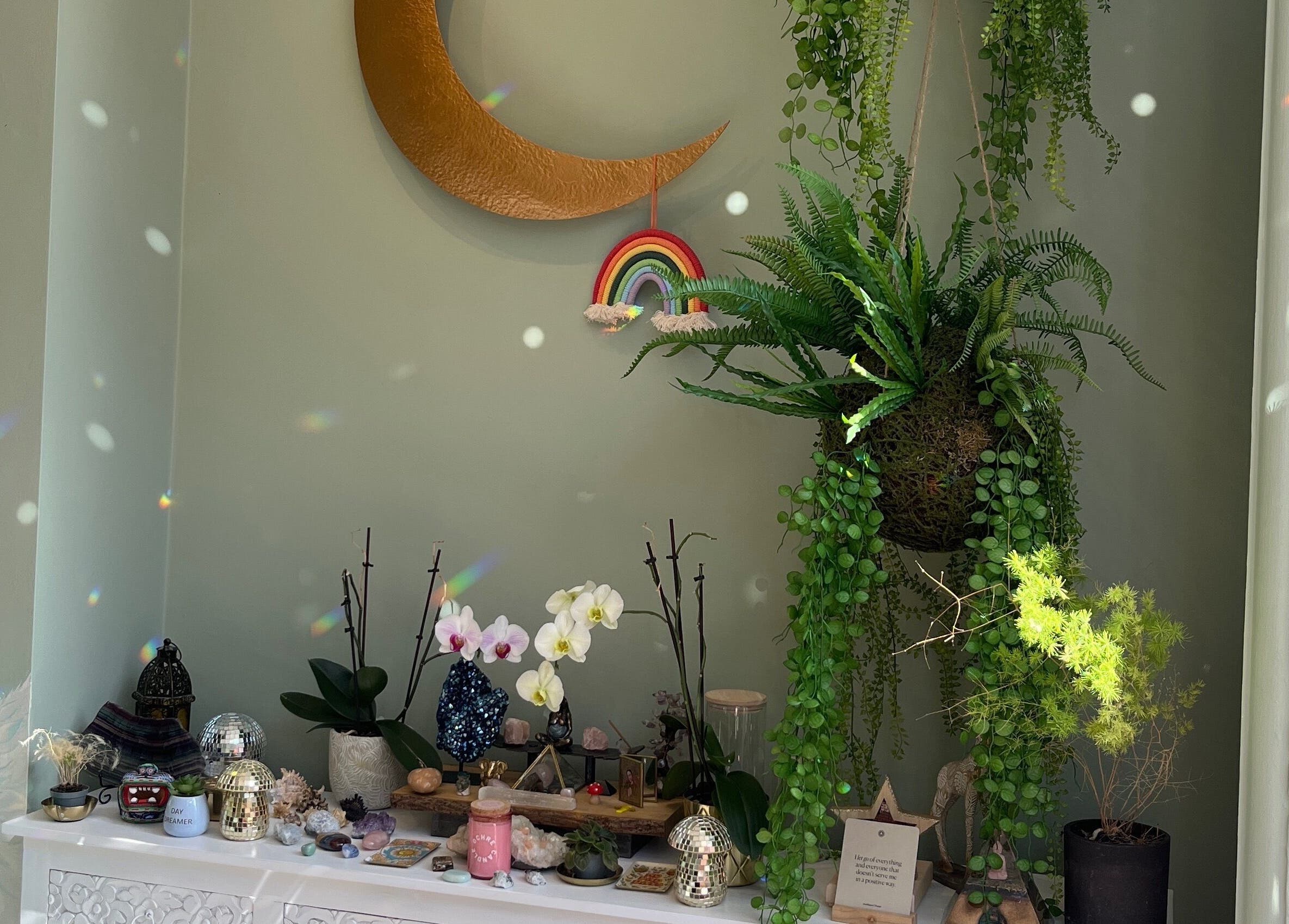Decorative nook at Alchemy Lab, Dublin, Dublin, IE with plants, crescent moon, and rainbow art.