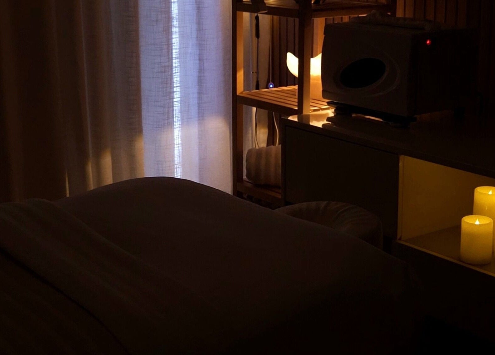 Cozy, candle-lit massage room at Koda Beauty Studio, Forrestdale, Western Australia, AU, offering a relaxing atmosphere.