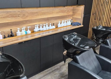 Chic wash stations at Revel Studio in London, Ontario, CA, featuring modern black basins and sleek design.